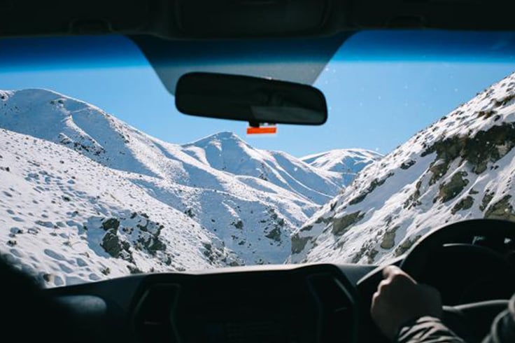 Snowy mountain view through car windscreen